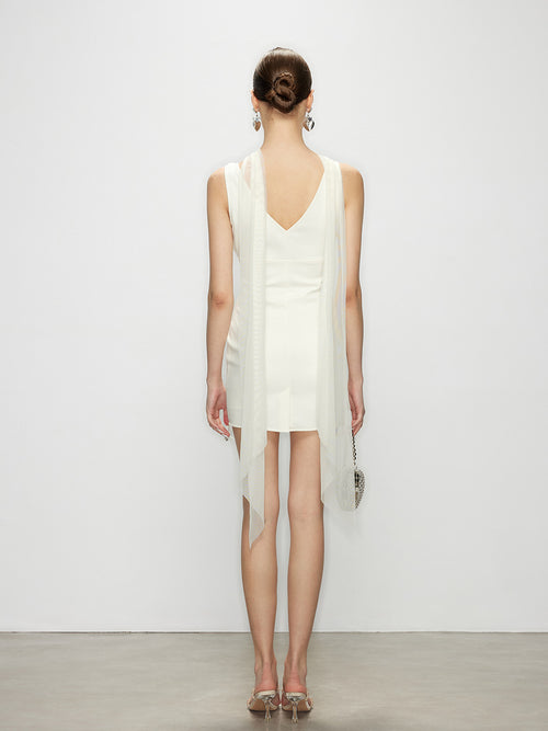 Back view of the bodycon dress in eclipse white, highlighting the open back design and draped tule fabric streamer.