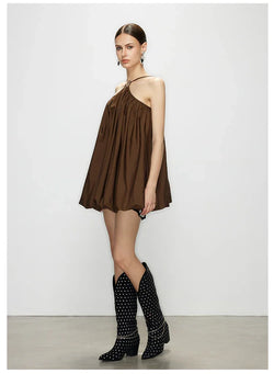 Model wearing Élan Brown Halter Bubble Mini Dress with voluminous bubble hem, paired with black studded cowboy boots.