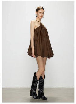 Three-quarter side profile of model wearing Élan halter neck bubble dress, detailing the voluminous bubble hem and draped chocolate brown fabric.