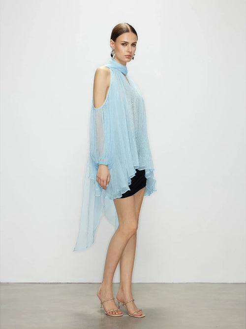 Side view of the light blue tie top highlighting the open cold shoulder design, draped back, and elegant sheer tulle.