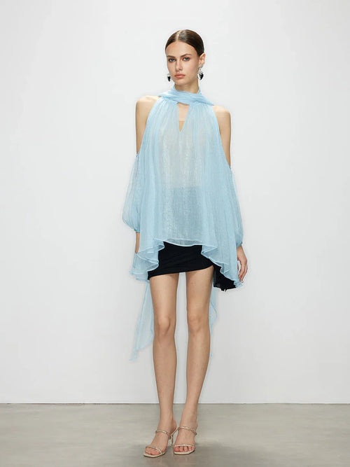 Model wearing the Aurorette light blue tulle cold shoulder top with a high neck tie and airy, sheer drape.