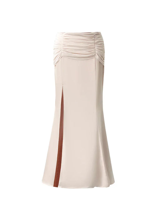 Product shot of dahlia: light pink satin high waist skirt showing the front design, side slit, and ruched waistband