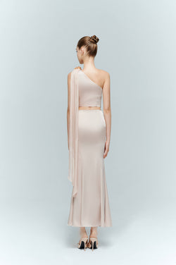 Back view of a model wearing dahlia: a flowing pink maxi skirt paired with a matching draped seraphine top