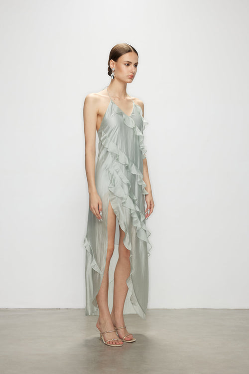 Side angle of the minimalist elegant Wavekiss dress with high slit, displaying the structural lines and flowing blue fabric.