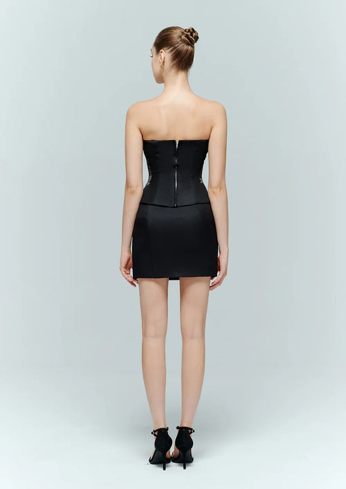 Back view of a model wearing the Marcelline classic black corset, displaying the premium matte black fabric and discrete back zipper closure.