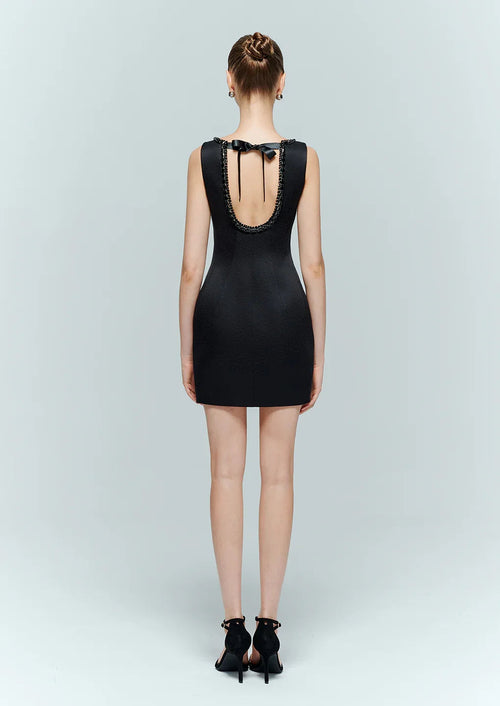 Full back view of the black backless dress featuring an elegant tie back design