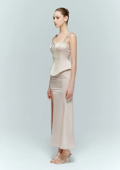 Side profile of a model highlighting the structured, snatched-waist fit of the Papillon pink bustier top and flowing skirt.