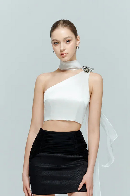 Model wearing the Seraphine white crop top paired with a contrasting black mini skirt, highlighting the minimalist elegant one-shoulder design.