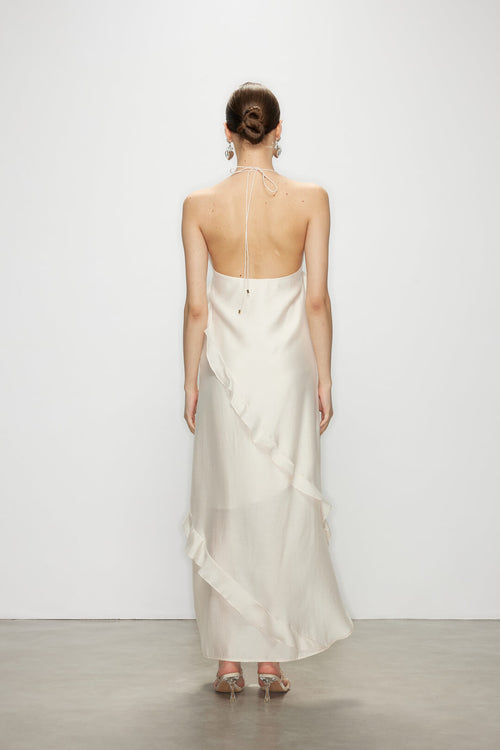 Back view of the minimalist elegant white ruffle dress, showcasing the open back and delicate neckline tie.